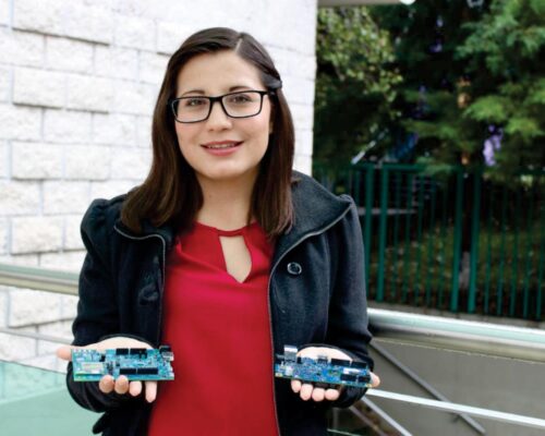 Mujer de pie y de frente, sostiene en sus manos dos chips